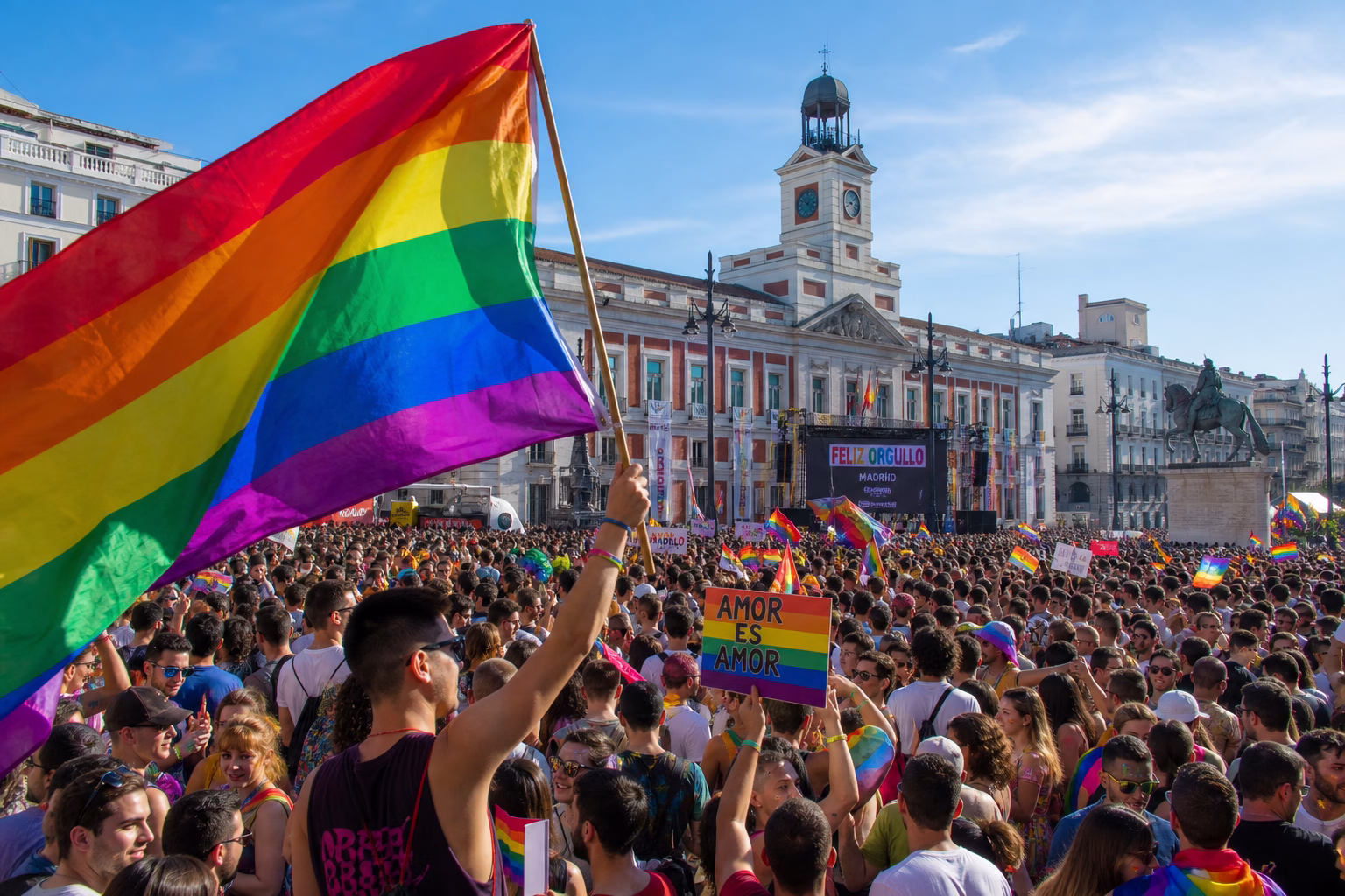 Manifestación del Orgullo Madrid con la bandera arcoíris y el Palacio de Cibeles al fondo